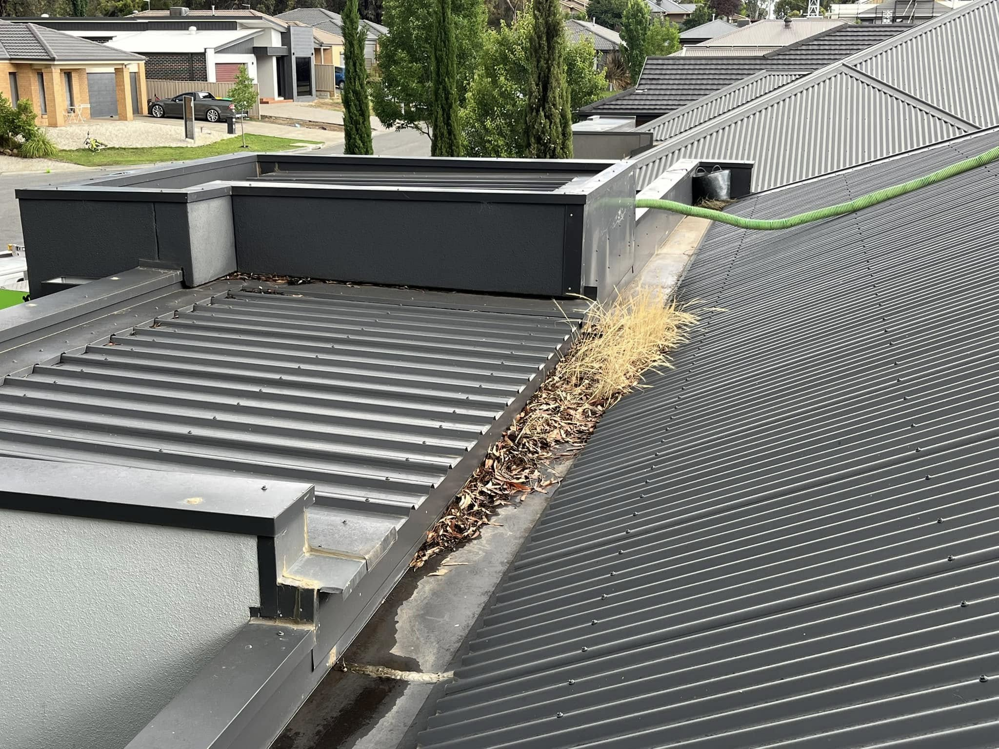 Gutter cleaning in Bendigo with vacuum hose clearing debris from roof gutters